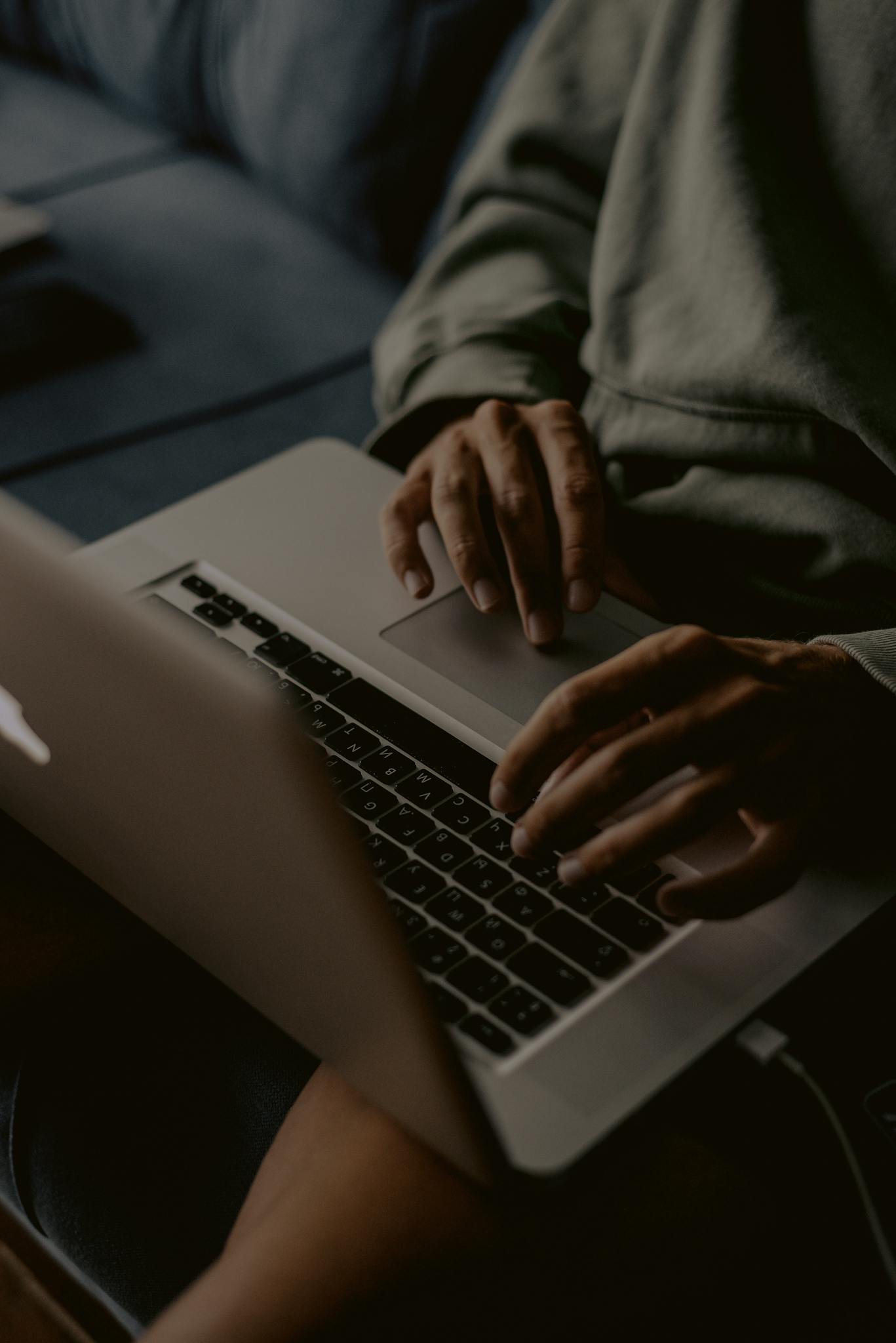 Close-up of hands typing on a laptop indoors, perfect for work-from-home themes.